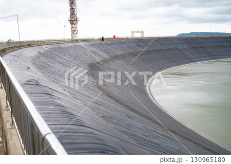 HDPE plastic lined water reservoirs and landscape of wind farm for power generating stations. High density polyethylene engineering material. Wind power. Sustainable, renewable energy. Windmill farm. 130965180