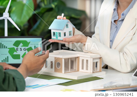 ESG focus. Professionals showcasing sustainable housing models in a collaborative meeting. 130965241