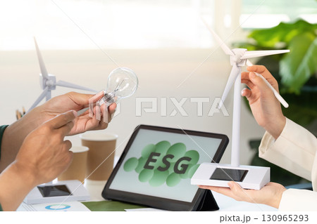 ESG strategy meeting with wind turbine model and light bulb in focus 130965293
