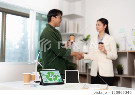 ESG Partnership. Professionals shaking hands over sustainable business initiatives. 130965340