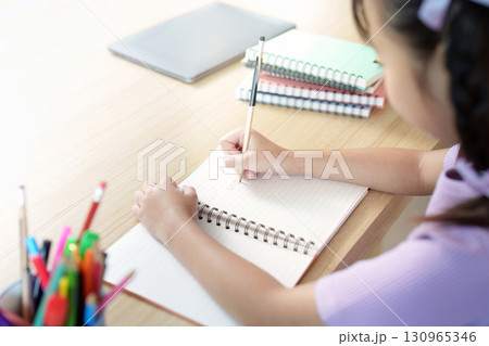 Back to School. Close-up of girl writing in notebook at study desk. 130965346
