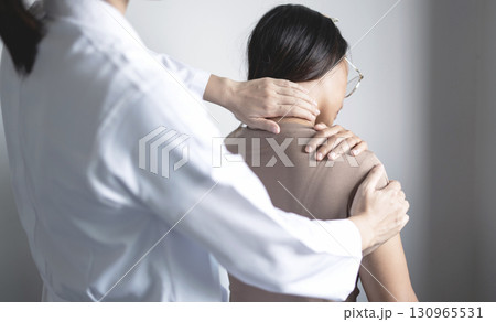 Female physiotherapists provide physical assistance to woman patients with shoulder injuries massaging their shoulders for muscle recovery in the rehabilitation center. Physiotherapy concepts 130965531