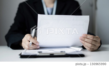 Business woman employer holding resume hiring recruit looking cv resume to hire candidates, analyzing information before job interview. Recruitment concepts 130965990