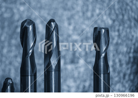 Close-up scene the group of used coating cutter ball nose end mill tools in the light blue scene. 130966196