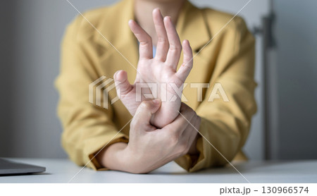 Woman hand with wrist pain numbness and pain in the palm of the hand has pain and tingling in the nerve endings This is a side effect of sitting and working for a long time on a laptop at the office 130966574