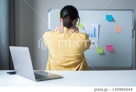 Woman having shoulder pain pain during work long time. stretching to relax and relax while working hard at the office 130966844