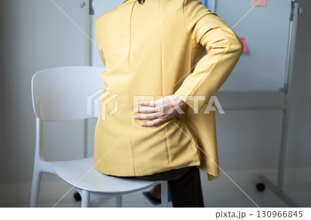 Woman having back body pain during work long time. stretching to relax and relax while working hard at the office Woman having back body pain during work long time. stretching to relax and relax while working hard at the office 130966845