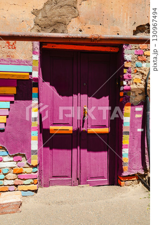 Colorful purple door with vibrant patterns in a historic neighborhood during daylight Colorful purple door with vibrant patterns in a historic neighborhood during daylight 130967494