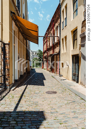 Cobblestone alleyway in an urban area with charming architecture on a sunny day Cobblestone alleyway in an urban area with charming architecture on a sunny day 130967504