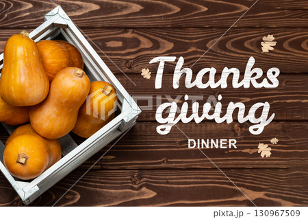 Thanksgiving dinner decor with fresh squash arranged in a wooden crate on a rustic table Thanksgiving dinner decor with fresh squash arranged in a wooden crate on a rustic table 130967509