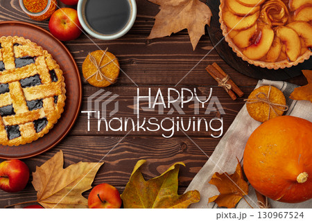 Thanksgiving celebration with delicious pies, apples, and autumn decorations on a wooden table Thanksgiving celebration with delicious pies, apples, and autumn decorations on a wooden table 130967524