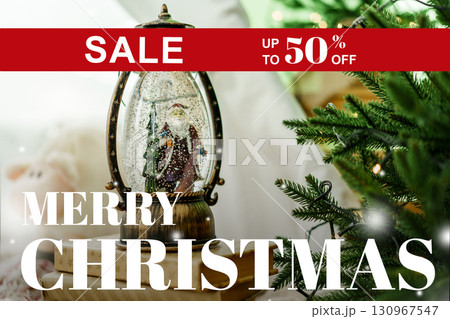 Holiday sale featuring a snow globe with a Christmas scene and festive decorations Holiday sale featuring a snow globe with a Christmas scene and festive decorations 130967547
