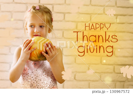 Girl holding pumpkin in festive setting during Thanksgiving celebration 130967572