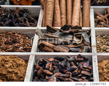 Various spices displayed in wooden boxes at a market stall during a sunny afternoon 130967783
