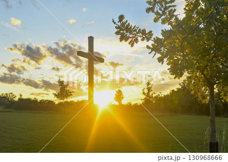A large Christian cross in the landscape. A Christian cross illuminated by the sunset. The concept of religion and Christianity. A large Christian cross in the landscape. A Christian cross illuminated by the sunset. The concept of religion and Christianity. 130968666