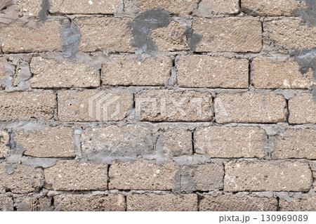 Close-up view of a rough brick wall, background photo texture 130969089