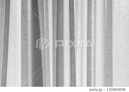 A minimalistic close-up of light white sheer fabric curtains with texture a 130969096