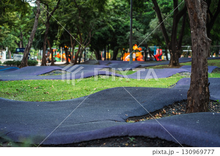 cushioned path for kids cycling or skating in park, soft track for children riding scooters or bikes and bicycle in safe playground area cushioned path for kids cycling or skating in park, soft track for children riding scooters or bikes and bicycle in safe playground area 130969777