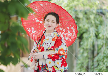 和傘を持った着物姿の若い女性 130969928