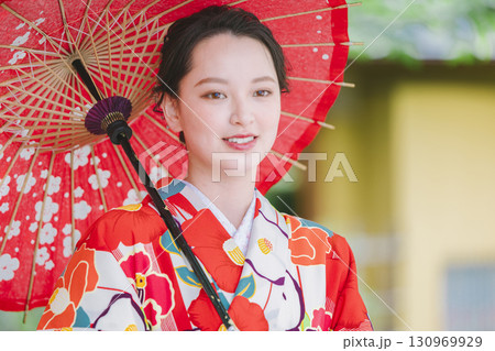 和傘を持った着物姿の若い女性 130969929