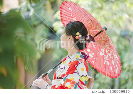 和傘を持った着物姿の若い女性 130969930