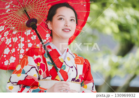 和傘を持った着物姿の若い女性 130969932