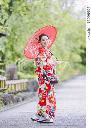 和傘を持って観光をする着物姿の女性 130969934