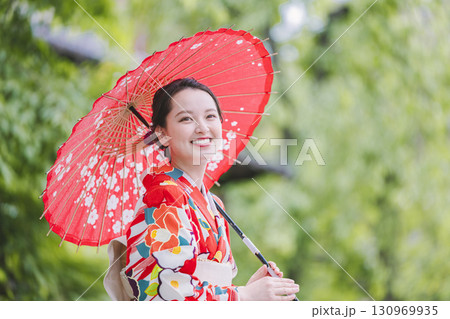 和傘を持った着物姿の若い女性 130969935