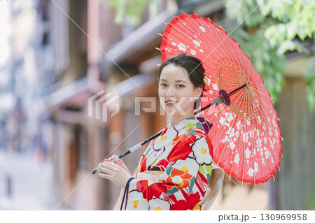 和傘を持った着物姿の若い女性 130969958