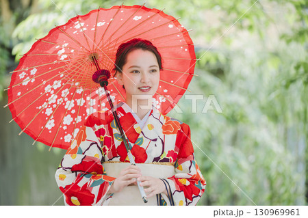 和傘を持った着物姿の若い女性 130969961