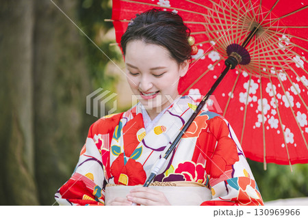 和傘を持った着物姿の若い女性 130969966