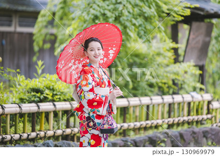 和傘を持って観光をする着物姿の女性 130969979
