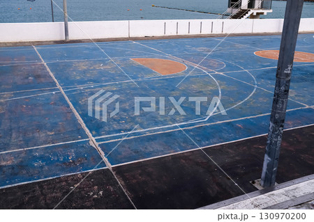 The scene of outdoor basketball court with seascape and skyscape. Outdoor sports and recreation court. Nobody in the basketball court in the sunny day. Sports and recreation concept. The scene of outdoor basketball court with seascape and skyscape. Outdoor sports and recreation court. Nobody in the basketball court in the sunny day. Sports and recreation concept. 130970200