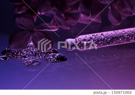 Cosmetic pipette with serum and lilac flowers. Cosmetic pipette with serum and lilac flowers. 130971068