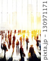 A blurry crowd of business people in a large, bright business hall. A dynamic scene unfolds in the bright business hall, filled with a blurry crowd of professionals exchanging ideas and networking. 130971171