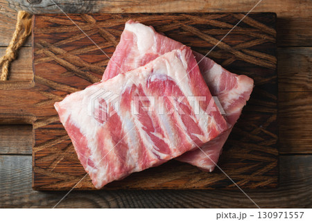 Raw pork ribs with spices, salt and rosemary on dark wooden background 130971557