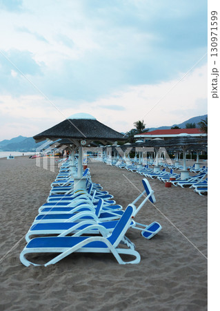 Empty deck chairs on tropical beach. Coast of Indian Ocean. Concept of recreation. Empty deck chairs on tropical beach. Coast of Indian Ocean. Concept of recreation. 130971599