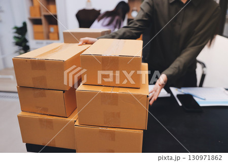Portrait of Starting small businesses SME owners, two Asian woman check online orders Selling products working with boxs freelance work at home office, sme business online small medium enterprise 130971862