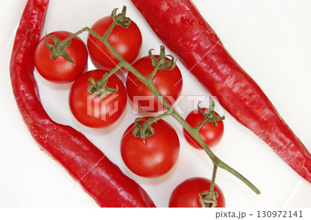 cherry tomatoes and pods of chili peppers isolated 130972141