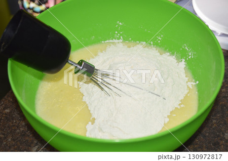 female hands with a whisk mix ingredients for baking dessert 130972817