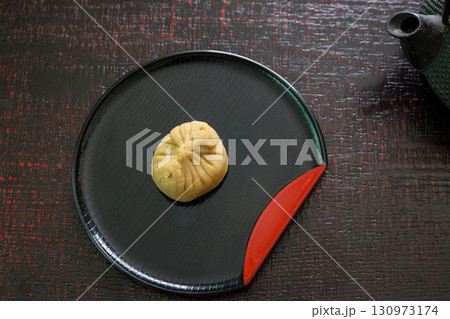 木製テーブルに置かれた皿にのせた栗きんとん 130973174