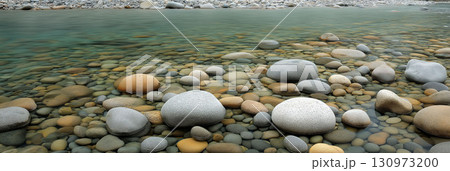 Smooth multicolored pebbles visible through clear shallow river water creating a natural tranquil scene 130973200