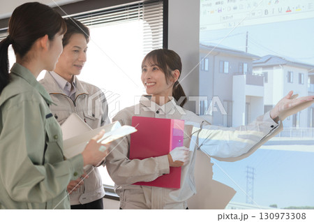 スクリーンの前で宅地開発の打ち合わせをする3人の男女 130973308