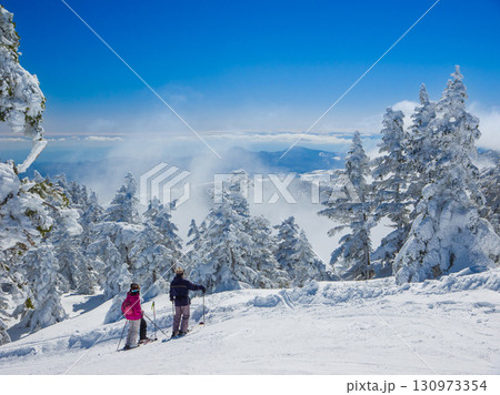 ゲレンデで樹氷と雲が作り出す絶景を眺めるスキーヤー達 (群馬県、中之条町、渋峠) ゲレンデで樹氷と雲が作り出す絶景を眺めるスキーヤー達 (群馬県、中之条町、渋峠) 130973354