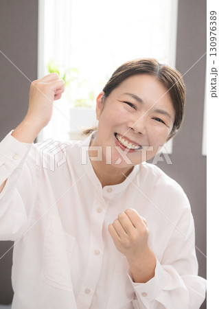 更年期も頑張るぞ～とガッツポーズをする40代後半の女性カメラ目線 130976389