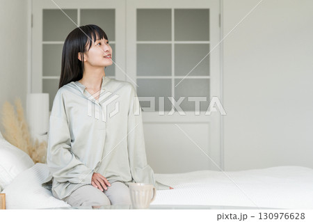 起床,目覚めた,起きたベッドに座る笑顔の女性 起床,目覚めた,起きたベッドに座る笑顔の女性 130976628