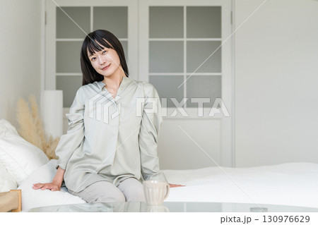 起床,目覚めた,起きたベッドに座る笑顔の女性 起床,目覚めた,起きたベッドに座る笑顔の女性 130976629