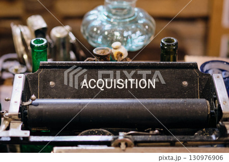 Copy space. Attraction of investments concept. ACQUISITION word written on Antique typewriter machine Copy space. Attraction of investments concept. ACQUISITION word written on Antique typewriter machine 130976906