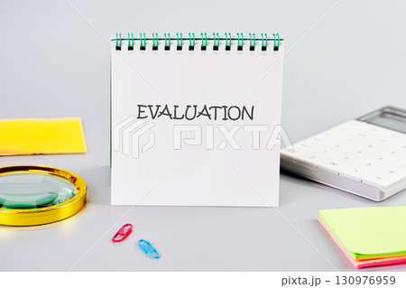 EVALUATION word written in a notebook in a composition with a calculator, a magnifying glass, and stickers. Business risk management concept EVALUATION word written in a notebook in a composition with a calculator, a magnifying glass, and stickers. Business risk management concept 130976959