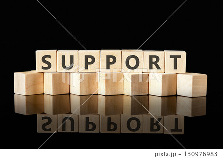 The concept word SUPPORT has been collected of wooden cubes on a glossy black background. Business and SUPPORT concept. Copy space The concept word SUPPORT has been collected of wooden cubes on a glossy black background. Business and SUPPORT concept. Copy space 130976983